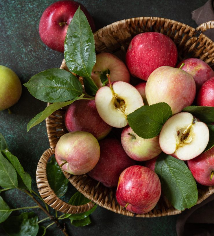 Fruit background, organic fruits. Still life food. Basket of ripe apples on a stone table. View from above.